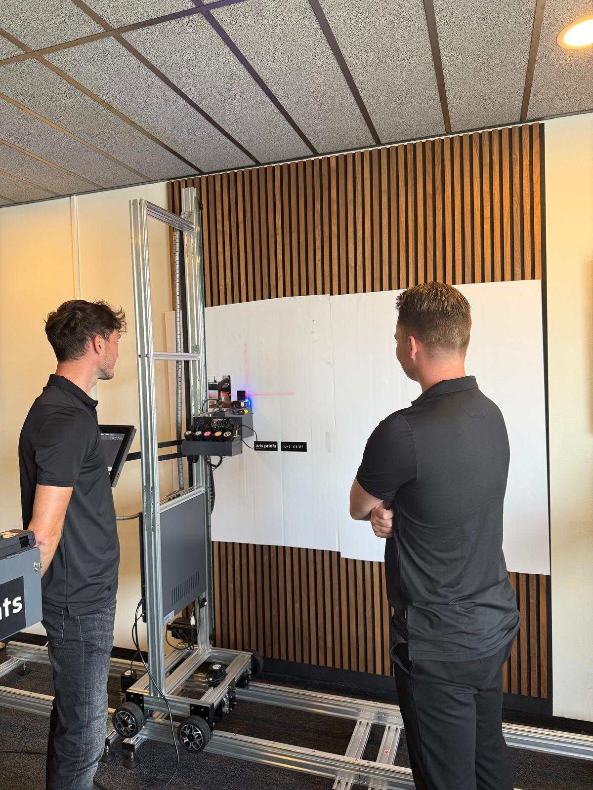 Laserkalibratie en eerste testprint van de wallprinter op een witte wand